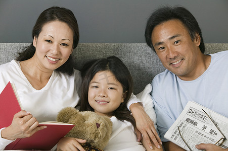 一个亚洲家庭在家里躺在床上放松的肖像
