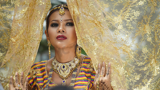 印度婚礼摄影照片_年轻新娘头戴婚礼头巾站在户外的肖像