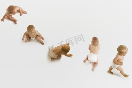 坐着婴儿摄影照片_一排婴儿在白色背景下坐着、爬着和走着