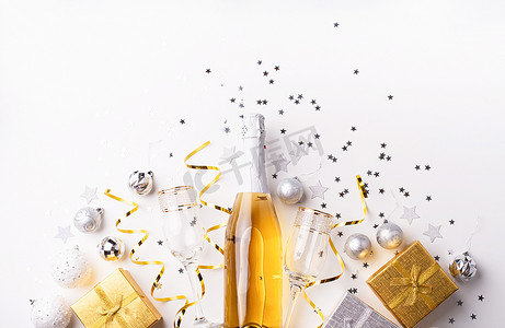 金色圣诞和新年派对装饰的顶视图，配有五彩纸屑和礼盒平躺