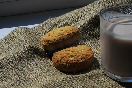 饼干和一杯酸奶放在粗麻布材料上