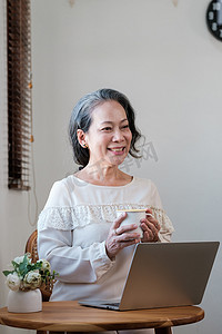 聪明的亚洲成熟中年女商人 CEO 老板领导教师使用笔记本电脑、电子学习、在家办公室远程在线工作