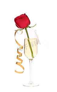 千库网飘带千库摄影照片_杯香槟和纸飘带中的红玫瑰。