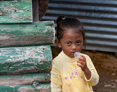 贫困女童摄影照片_一个可怜的尼泊尔女童疑惑地看着