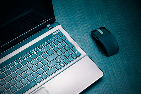 扁平电脑摄影照片_木桌上的笔记本电脑和现代扁平鼠标