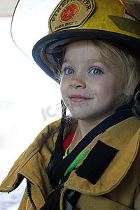 孩子消防员摄影照片_作为消防员的年轻女孩