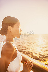 游轮豪华旅行优雅的女人从阳台套房甲板上欣赏日落美景。