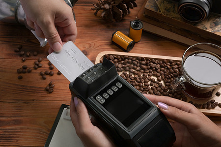 刷支付摄影照片_顾客在咖啡店用信用卡支付订单。