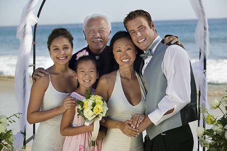 新娘和新郎与家人在海滩上