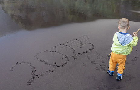 小孩在黑沙滩上写 2023 年