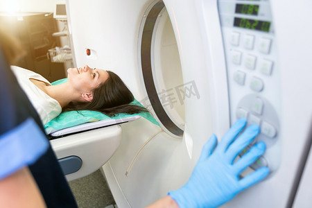 CT 扫描技术专家在准备手术过程中俯瞰计算机断层扫描仪中的患者。