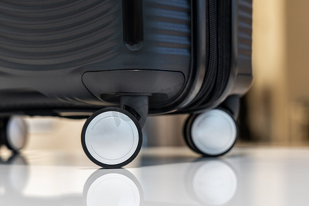 轮子上黑色塑料旅行手提箱的特写