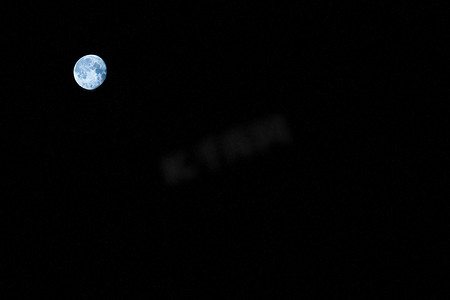 圆月光摄影照片_黑色背景上遥远的圆月。纹理或背景