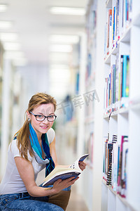 漂亮的女大学生在图书馆里找书