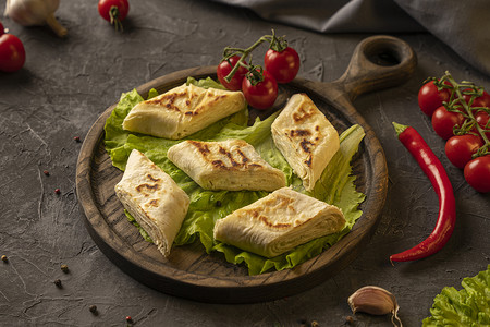 泡芙塔摄影照片_美味的油炸皮塔饼面包卷配奶酪和香草