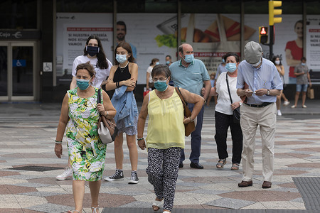 西班牙萨拉戈萨 — 2020年8月18日：戴着口罩走在人行横道上的人