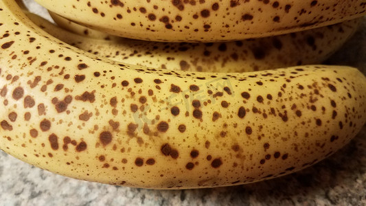 皮肤斑点摄影照片_柜台上有斑点的成熟香蕉果