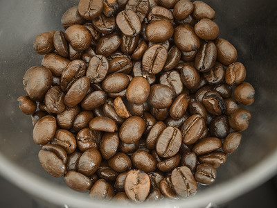 咖啡饮料海报摄影照片_研磨机中的咖啡豆