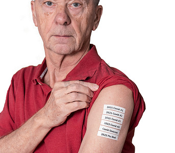 老人展示他手臂上所有的 Covid 和流感疫苗