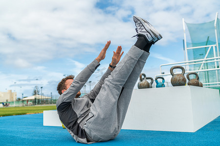 Abs 锻炼抬腿脚趾接触仰卧起坐锻炼男子力量训练在健身健身房运动场。