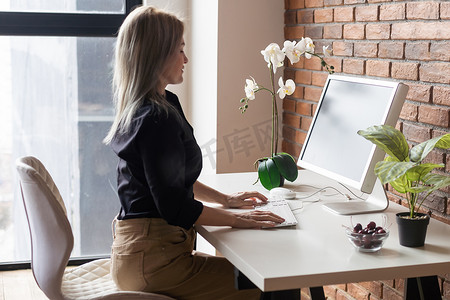网站关于摄影照片_成功的女性图形设计师在办公室工作过程中观看关于电脑创意的教程。
