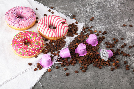 浓咖啡粉色塑料胶囊，配有箔纸、咖啡豆和甜甜甜圈