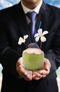 饮料饮品菜单摄影照片_商人在海滩旁提供椰子饮料，饮料业务
