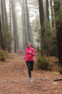 在森林树林训练中跑步的女人