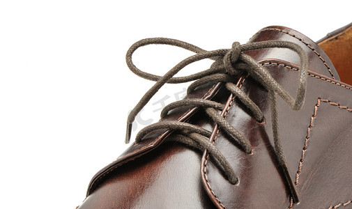 鞠躬的人摄影照片_从棕色皮革的人的鞋子