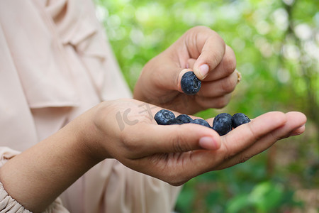 户外吃蓝莓水果的妇女