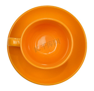 碟子俯视图摄影照片_带碟子的橙色杯子
