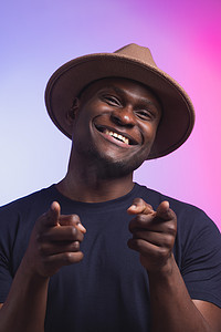 戴帽子的非洲裔美国人用手指指着你和相机，微笑着积极开朗 — 多样性和有趣的概念