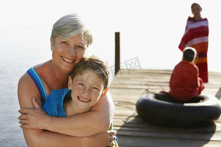 快乐的老年妇女在码头上与姐妹拥抱孙子的肖像