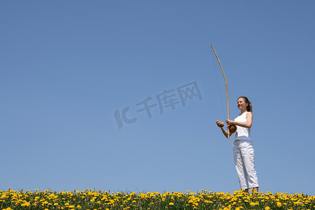 在春天的草地上玩 berimbau 的女孩