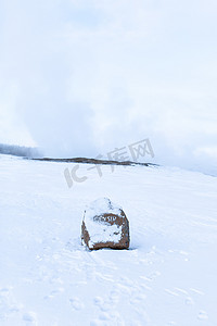 冰岛冬季积雪覆盖的铭文间歇泉石标