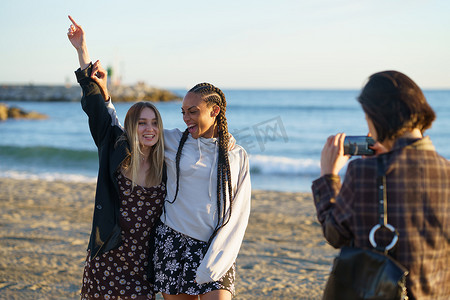 不露面的女人在海边拍摄快乐的多种族女友