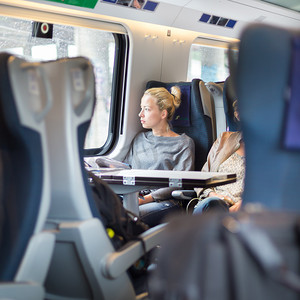 坐火车旅行摄影照片_坐火车旅行的女士。