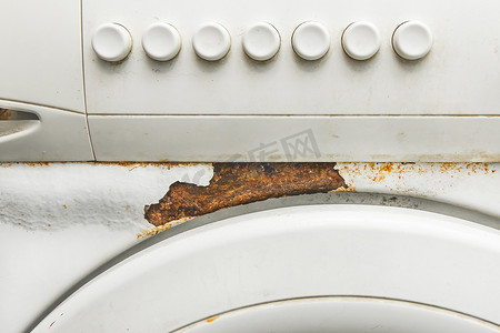 国潮海报案例分析摄影照片_一台旧白色洗衣机的外壳或正面，特写有锈迹和按钮控制面板