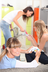 三个女室友在玩电子游戏。