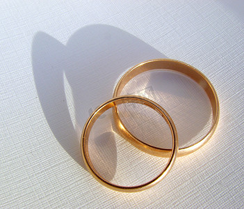 结婚金色摄影照片_白色背景中的两个结婚金戒指