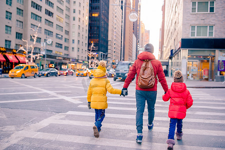 父亲和小孩在纽约市度假时在时代广场的一家人