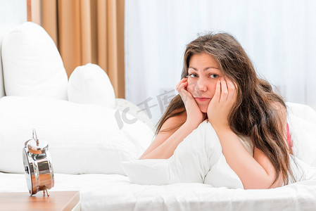 一个沮丧的女人早上躺在床上的肖像