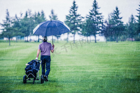 高尔夫球手在雨天离开高尔夫球场