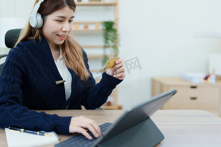 办事指南摄影照片_在线购物和互联网支付，美丽的亚洲女性正在使用信用卡和平板电脑笔记本电脑在线购物或在数字世界中办事