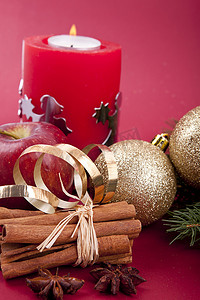 红色背景中的圣诞装饰红苹果、肉桂、茴香和树