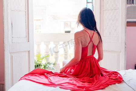 太古里摄影照片_哈瓦那公寓里穿着红色裙子的年轻漂亮女人