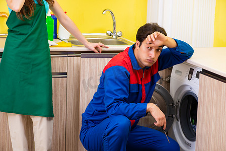 洗衣工摄影照片_在家修理洗衣机的承包商