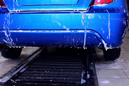 洗车时一辆蓝色汽车的背面特写。