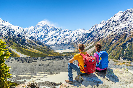 背包客夫妇徒步旅行，看着库克山在新西兰徒步旅行的山景。
