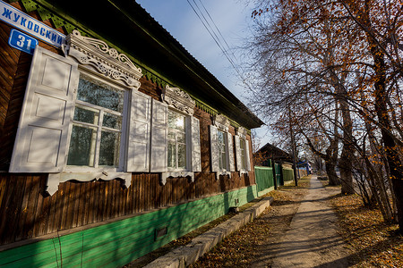 一座古老的单层木屋，带有俄罗斯风格的雕刻百叶窗。